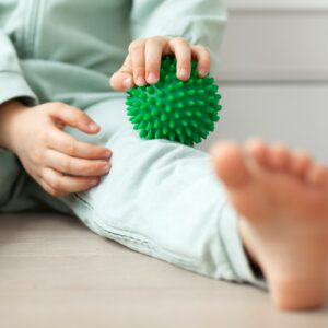 kid holding massage ball physical therapy and massage for development neuro psychology